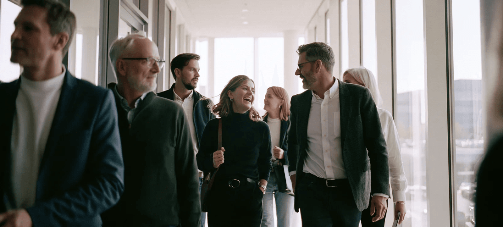 A team walking out of a meeting together, mid-laugh